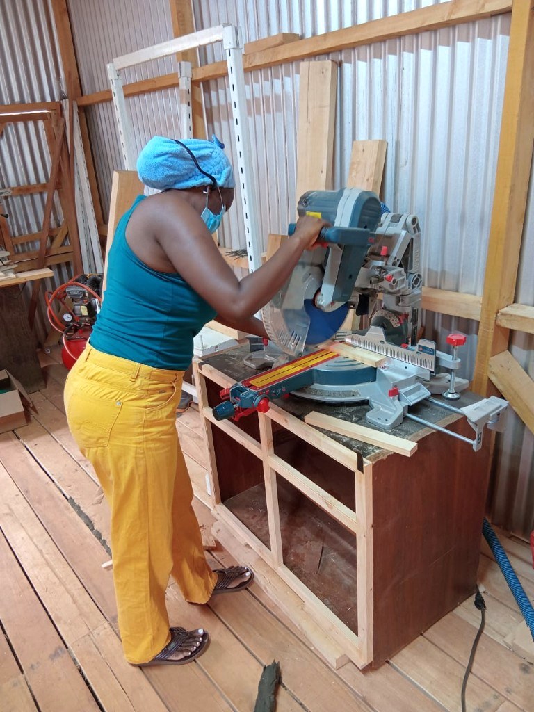 Artisan cutting timber on a miter saw in the Vintage Effects workshop